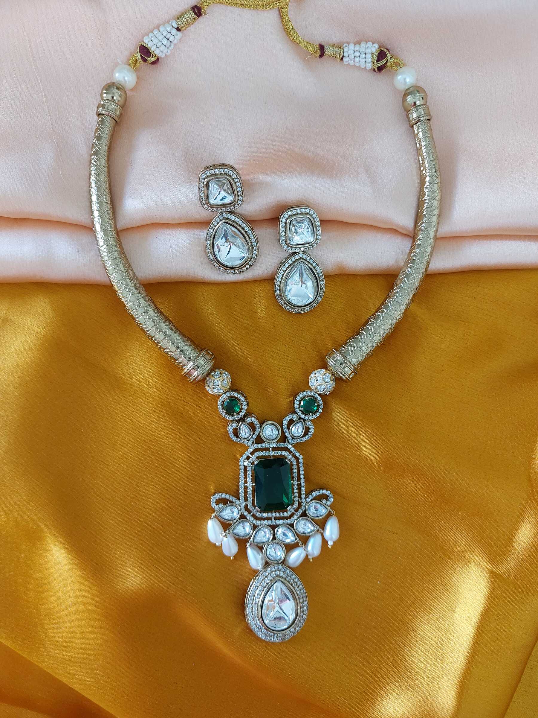 Malavika Green Stone Studded Moissanite Antique Gold Kundan Hasli Pearls Embelished Necklace Set With Earrings